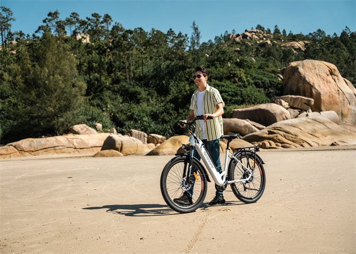 ride with a TESWAY Walker e-bike on a sandy beach with rocky hills and trees in the background